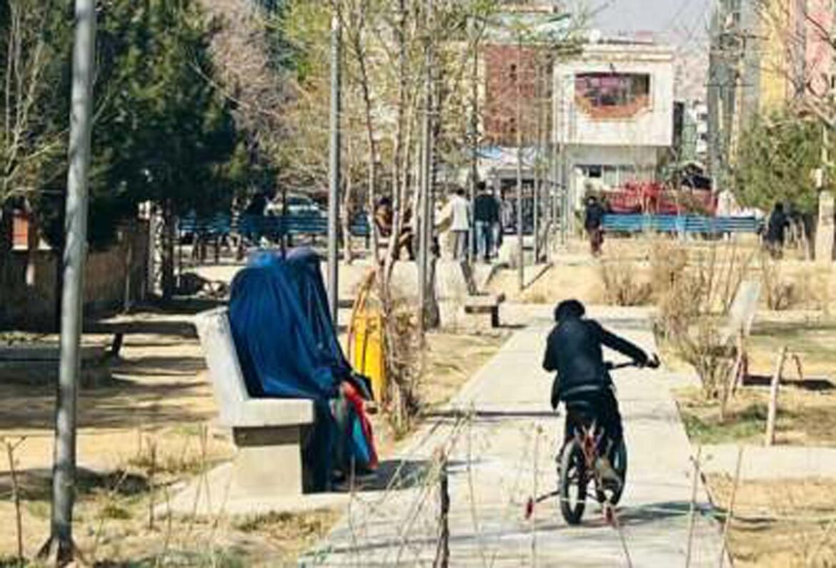Dos mujeres sentadas en una banca en Kabul, mientras cuidan a un niño que juega en una bicicleta. Según las nuevas leyes de los talibanes, una esposa que visite a sus familiares sin el permiso de su marido se enfrenta a hasta tres meses de prisión. Imagen: Learning Together